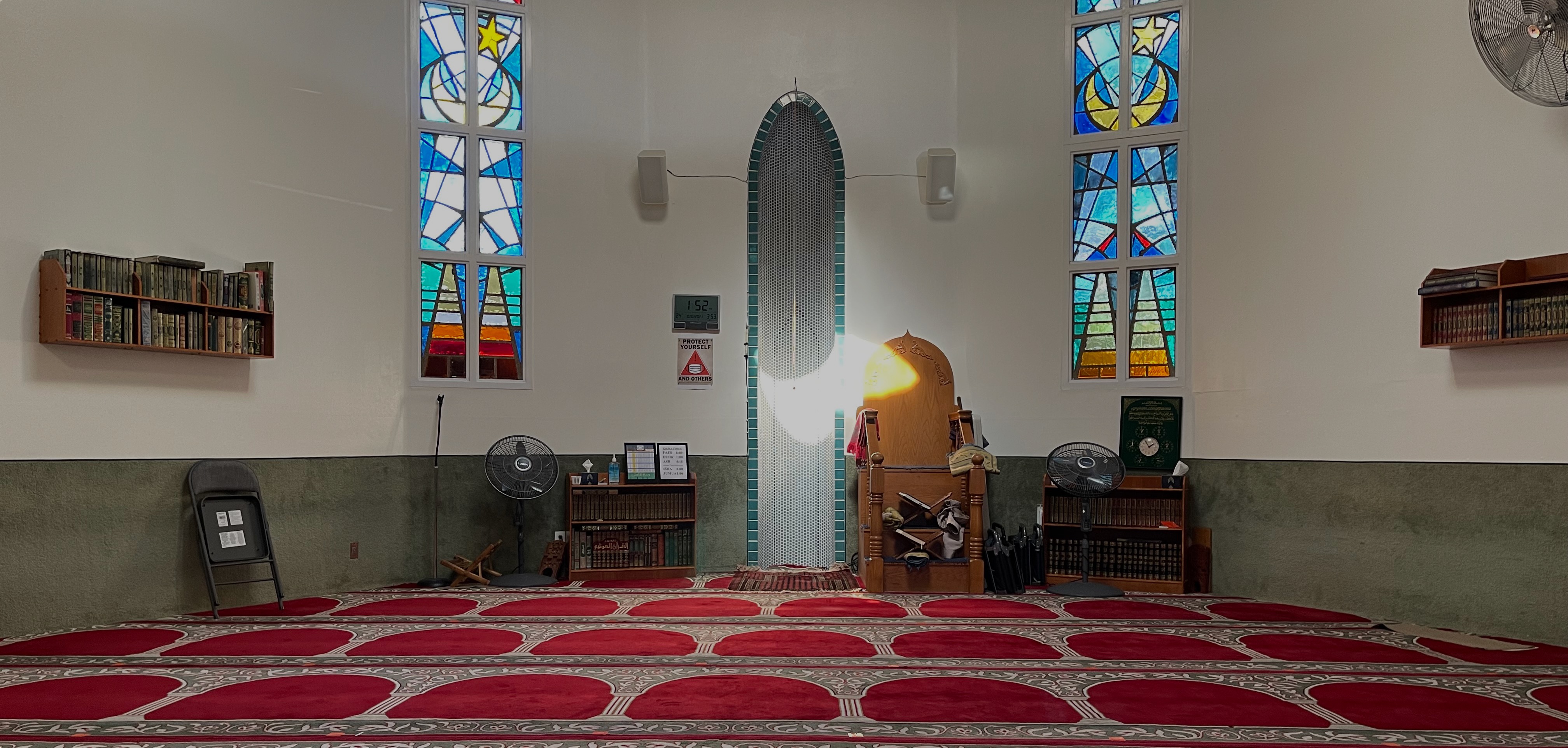 Prayer hall inside Al-Ribat Mosque with red carpet and mihrab