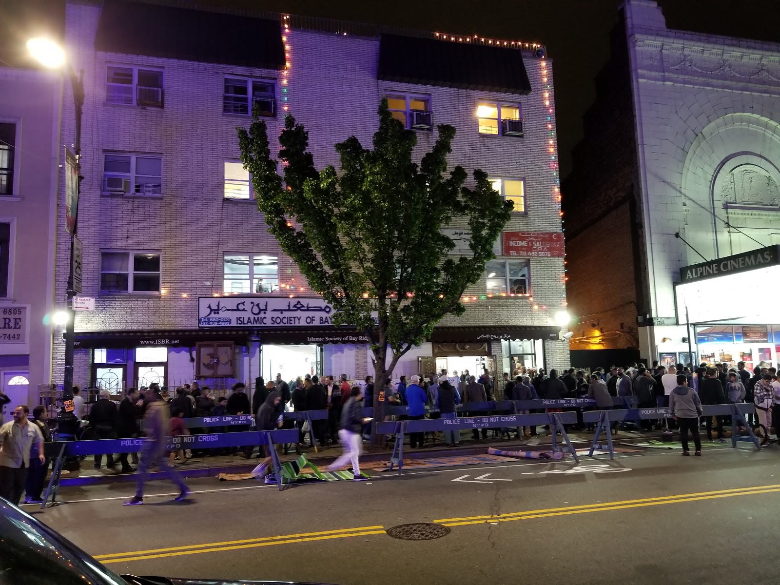 Islamic Society of Bay Ridge 5th Avenue exterior at night with worshippers outside