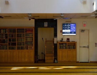 Masjed Assaber prayer hall with bookshelves and digital prayer display