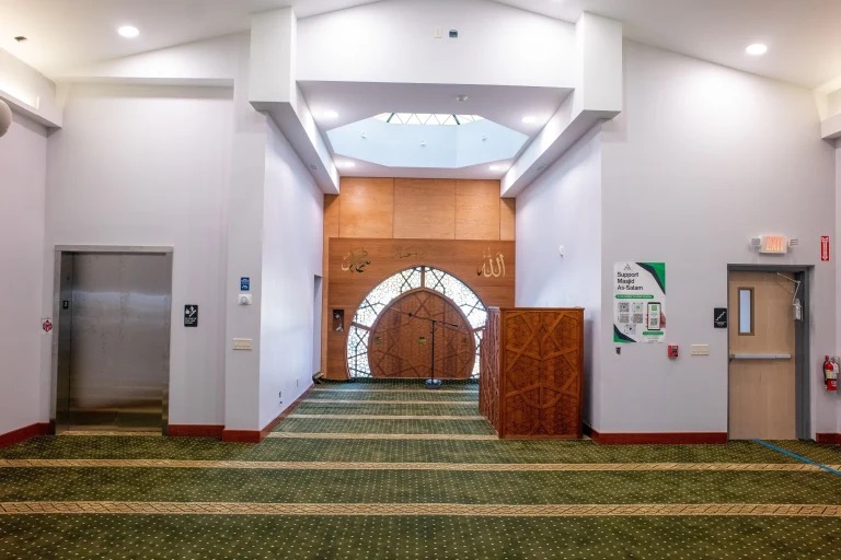 Masjid as-Salaam main prayer hall with mihrab and green carpet