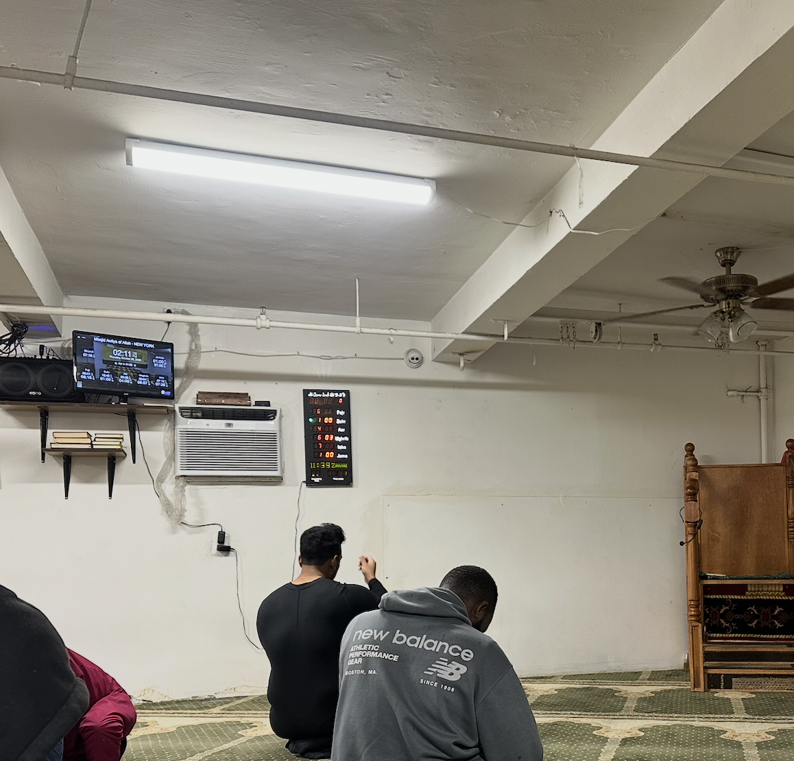Masjid Awliyah of Allah prayer room with salah time boards in Manhattan